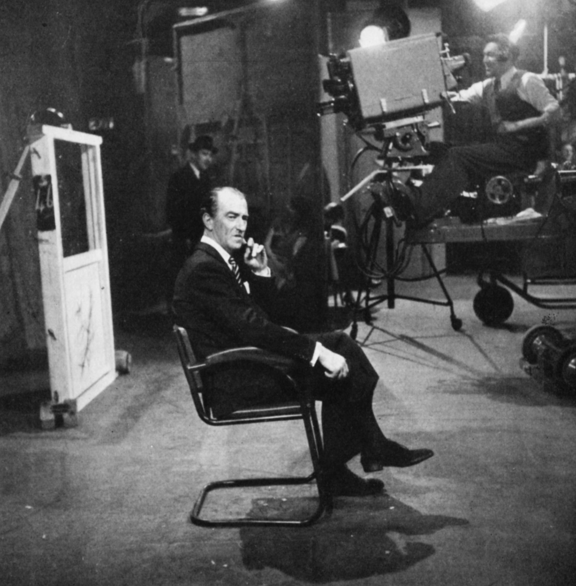 Dick Bentley sits in a chair at the back of a busy studio