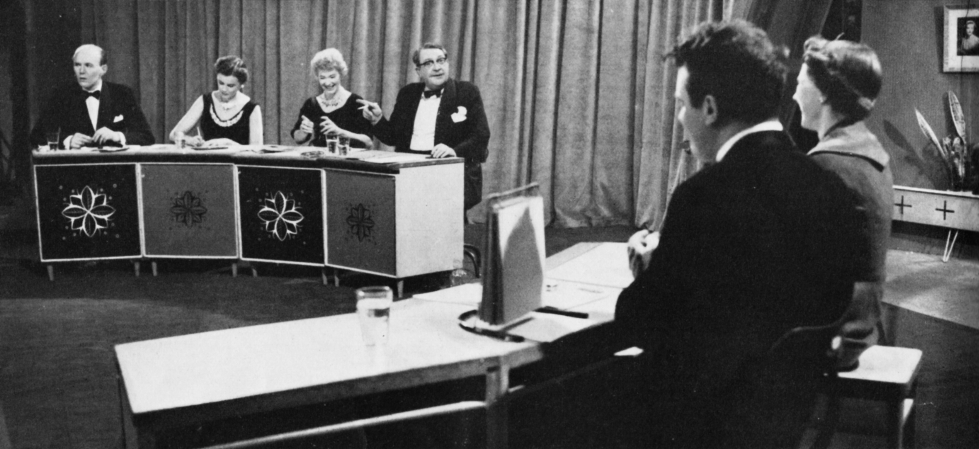 The What's My Line panel, Eamonn Andrews and the contestant sit behind desks